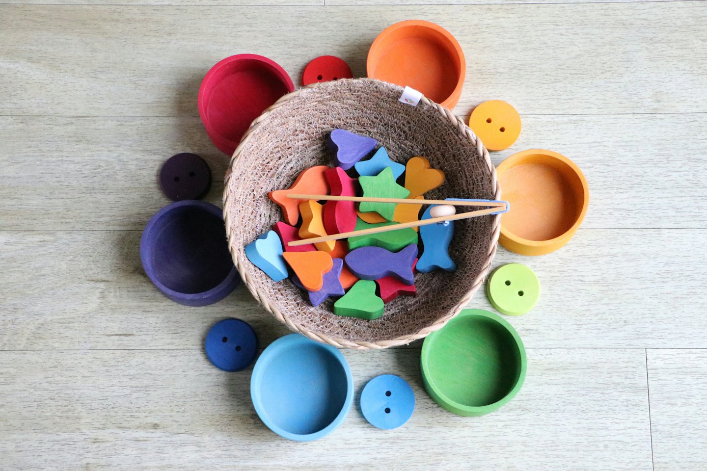 Giocattoli educativi di legno colorati che traboccano da un cesto di vimini.
