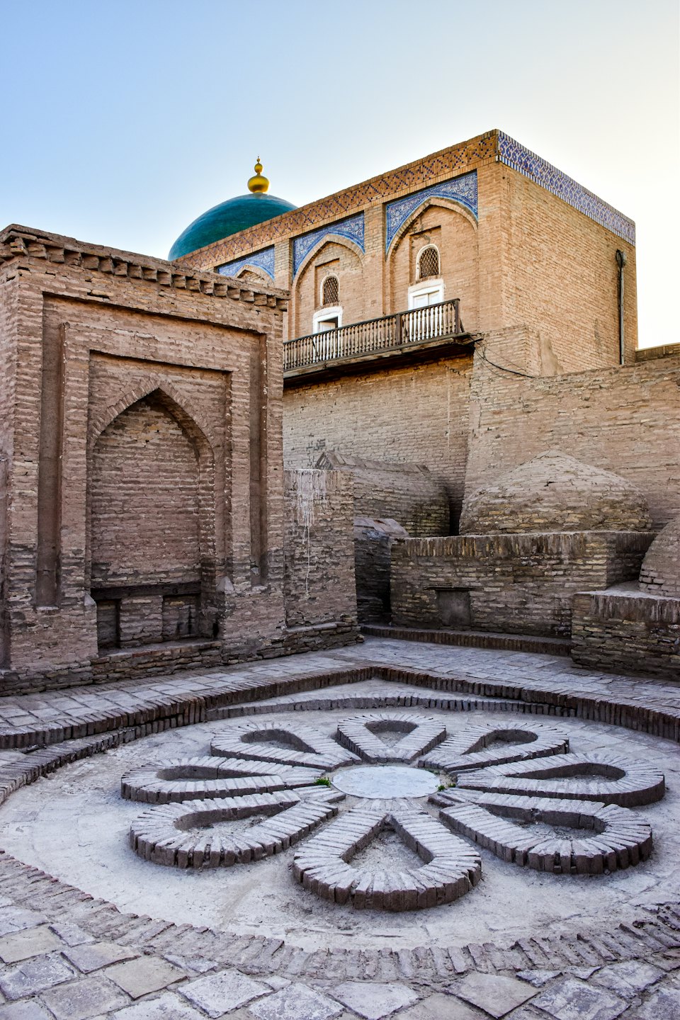 Edificio storico in mattoni con piastrelle blu e cupola verde.