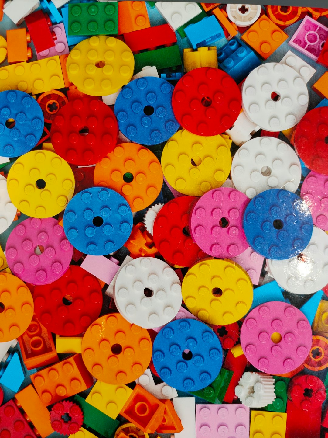Mattoncini giocattolo di plastica colorati sparsi su una superficie.